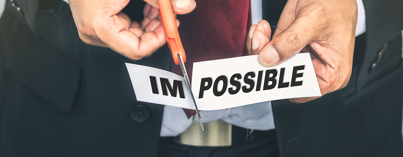 Closeup businessman cutting paper of impossible word